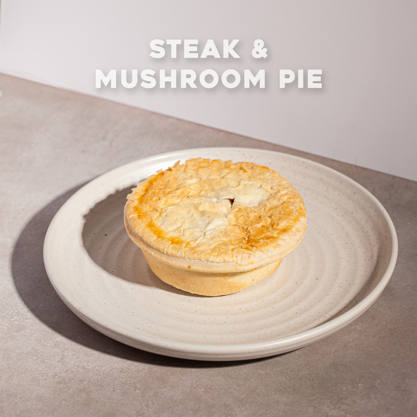 Steak & Mushroom Pie on a plate with Bourkies Bakehouse branding.