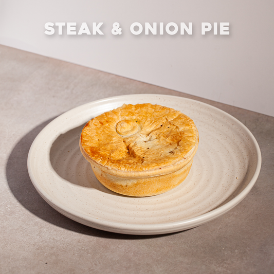 Steak & Onion Pie on a plate with Bourkies Bakehouse branding.